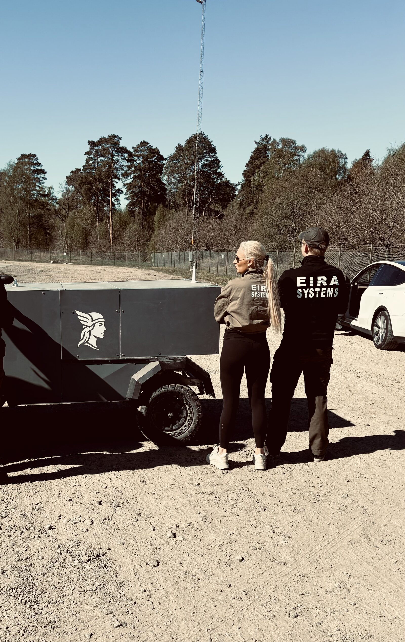 Eira team in branded jackets standing with the Eira X demonstrator.